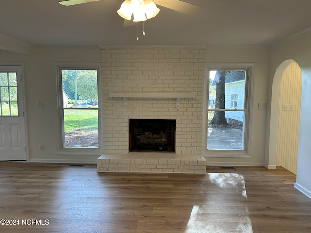 unfurnished living room with ceiling fan, a fireplace, dark hardwood / wood-style floors, and ornamental molding