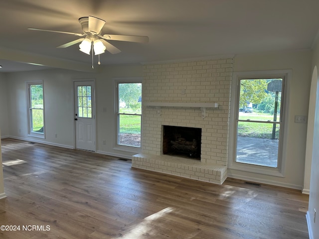 unfurnished living room featuring dark wood-type flooring, ceiling fan, and a fireplace