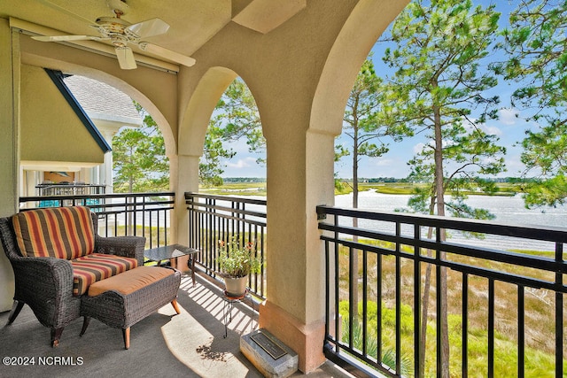 balcony featuring a water view and ceiling fan