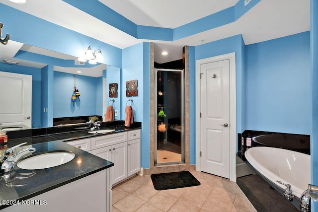 bathroom featuring tile patterned flooring, shower with separate bathtub, and vanity