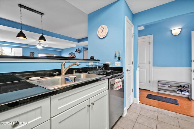 kitchen featuring white cabinetry, hanging light fixtures, sink, dishwasher, and light hardwood / wood-style flooring