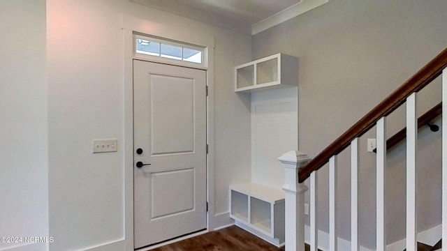 entrance foyer featuring crown molding and dark hardwood / wood-style flooring