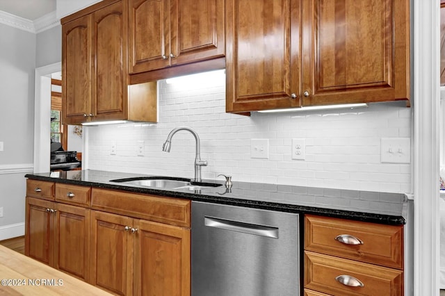 kitchen featuring tasteful backsplash, light hardwood / wood-style floors, stainless steel dishwasher, sink, and dark stone countertops