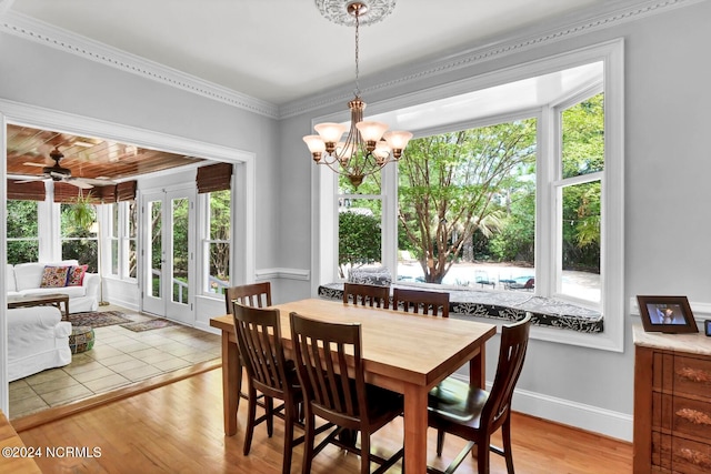 dining room featuring ceiling fan with notable chandelier, a wealth of natural light, light hardwood / wood-style floors, and ornamental molding