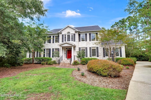 colonial inspired home featuring a front yard