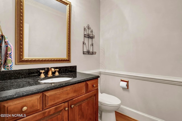 bathroom featuring vanity, toilet, and hardwood / wood-style floors