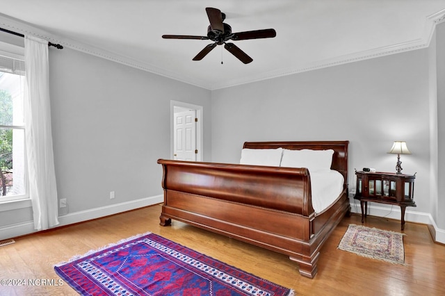 bedroom with hardwood / wood-style floors, ceiling fan, and crown molding