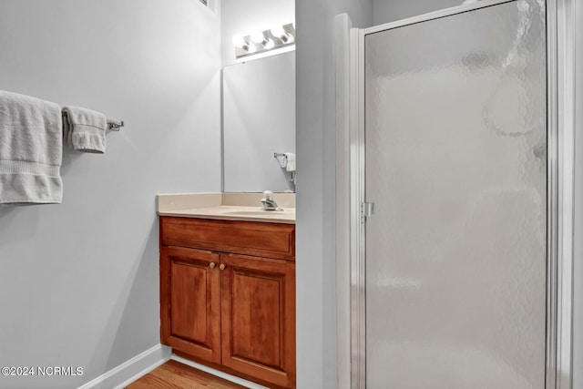 bathroom featuring an enclosed shower, hardwood / wood-style flooring, and vanity