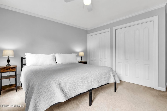 bedroom with crown molding, carpet flooring, ceiling fan, and multiple closets