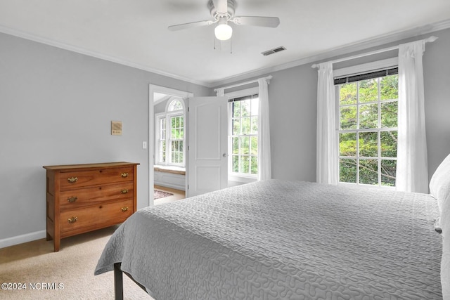 carpeted bedroom featuring ceiling fan and crown molding