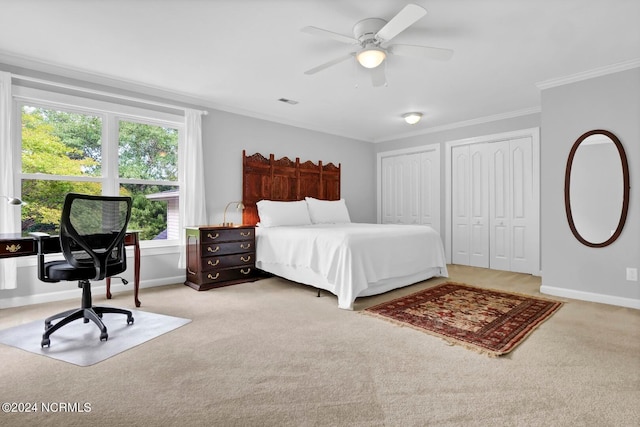 bedroom with crown molding, ceiling fan, multiple closets, and light colored carpet