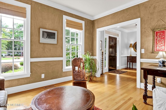 sitting room featuring a wealth of natural light, crown molding, and hardwood / wood-style flooring