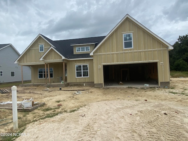 view of front facade with a garage, a porch, board and batten siding, and a shingled roof