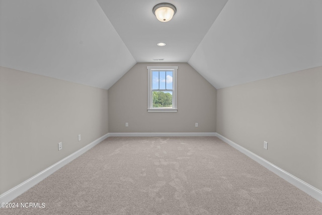 bonus room with light colored carpet and lofted ceiling