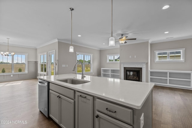 kitchen with decorative light fixtures, white cabinets, a kitchen island with sink, and appliances with stainless steel finishes