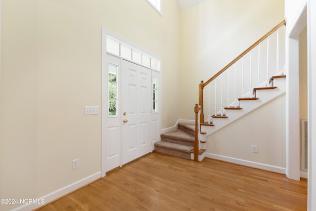 foyer entrance featuring a high ceiling and light wood-type flooring