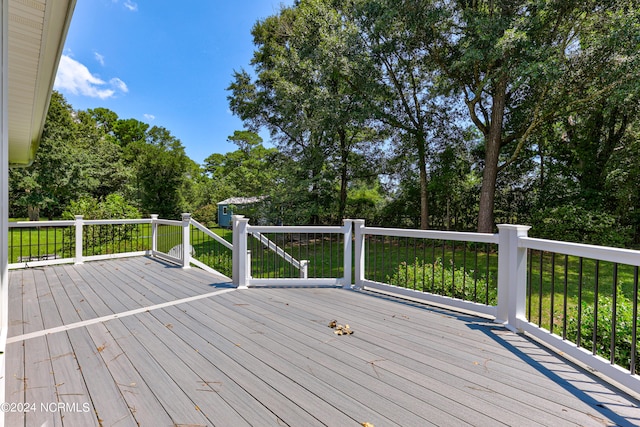 wooden terrace featuring a yard