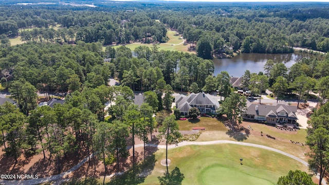 bird's eye view with view of golf course, a water view, and a view of trees