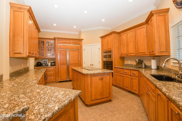 kitchen featuring light stone counters, a sink, a center island, brown cabinetry, and crown molding