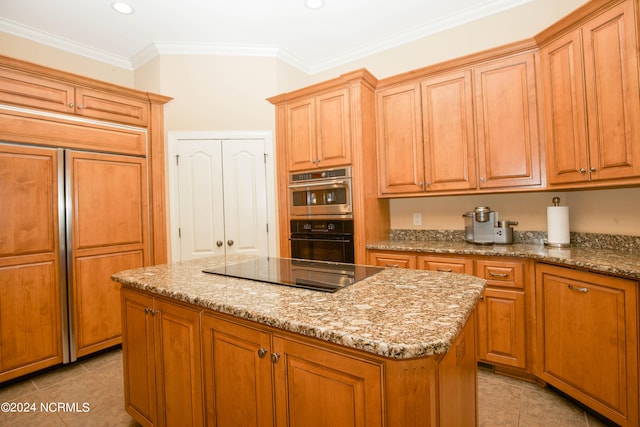 kitchen with black electric stovetop, stainless steel double oven, built in refrigerator, ornamental molding, and a center island