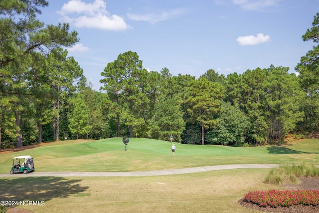 view of community featuring view of golf course and a lawn