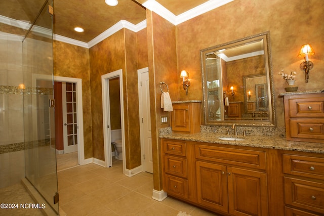 bathroom featuring a stall shower, toilet, ornamental molding, tile patterned flooring, and vanity