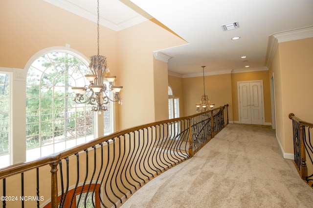 corridor featuring crown molding, carpet flooring, a notable chandelier, and visible vents