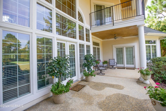 view of patio with ceiling fan and a balcony