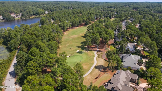 aerial view with view of golf course, a water view, and a wooded view