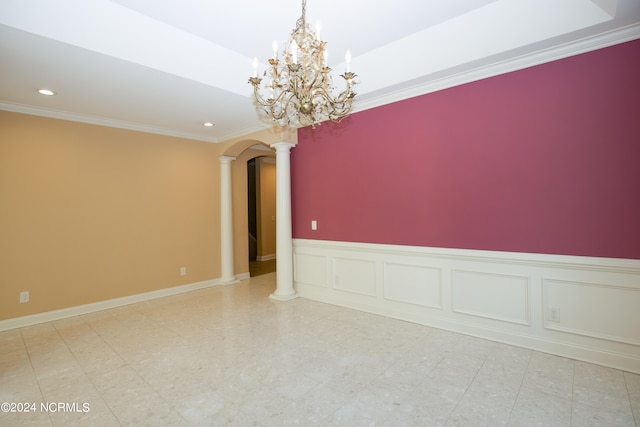 spare room featuring arched walkways, recessed lighting, a decorative wall, ornamental molding, and ornate columns