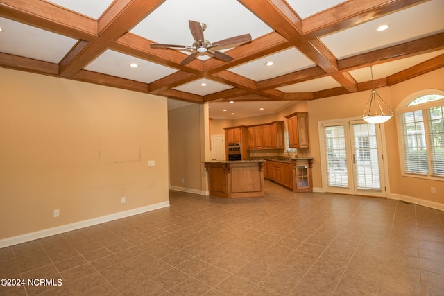 unfurnished living room featuring ceiling fan, baseboards, coffered ceiling, and beamed ceiling