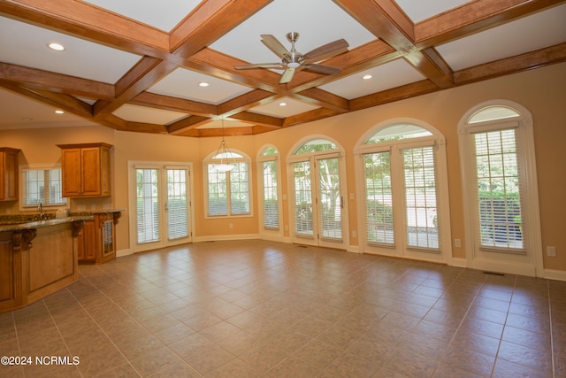 119 Saint Mellions Dr, Pinehurst, NC 28374 - unfurnished living room featuring beamed ceiling, baseboards, coffered ceiling, and a healthy amount of sunlight