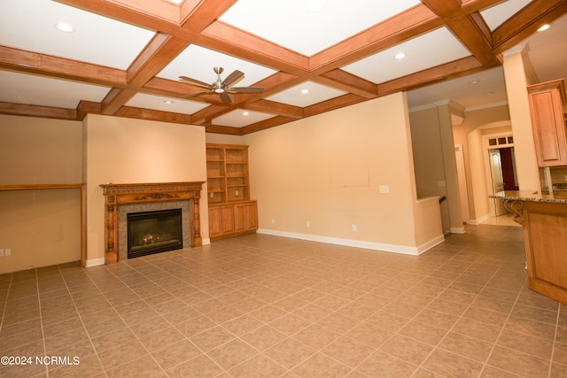 unfurnished living room with baseboards, coffered ceiling, a ceiling fan, a glass covered fireplace, and beamed ceiling