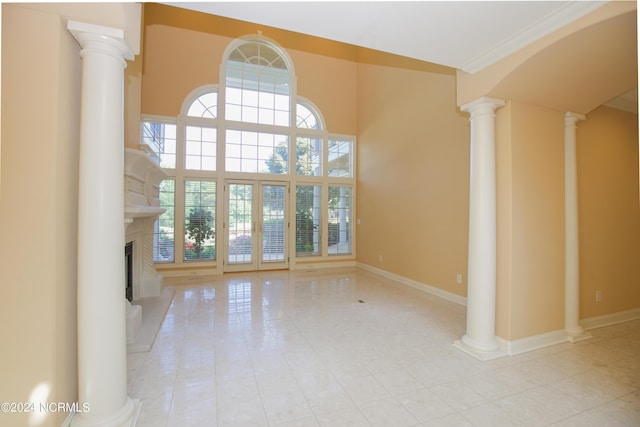119 Saint Mellions Dr, Pinehurst, NC 28374 - unfurnished living room with decorative columns, a fireplace with raised hearth, a high ceiling, tile patterned floors, and baseboards