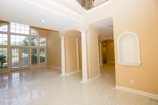 unfurnished room featuring decorative columns, crown molding, visible vents, and baseboards