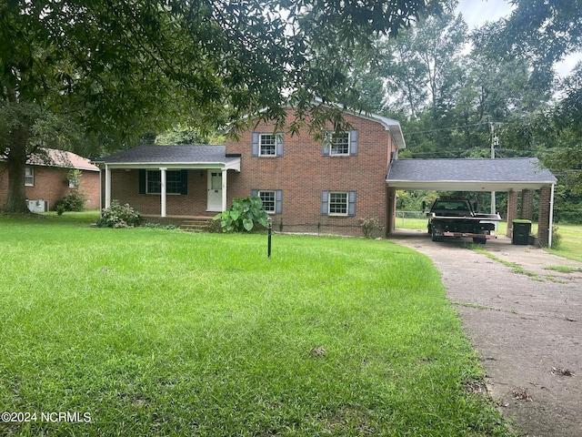 split level home with driveway, covered porch, a front yard, a carport, and brick siding