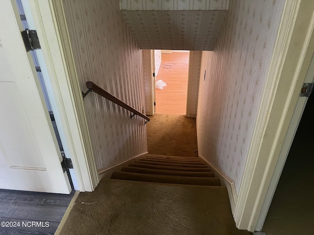 stairway featuring wallpapered walls