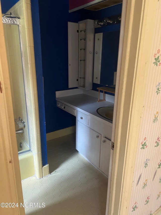 bathroom featuring tile patterned flooring, bathtub / shower combination, baseboards, and vanity