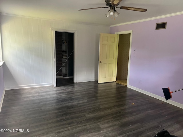 interior space with a walk in closet, hardwood / wood-style floors, ornamental molding, a closet, and ceiling fan