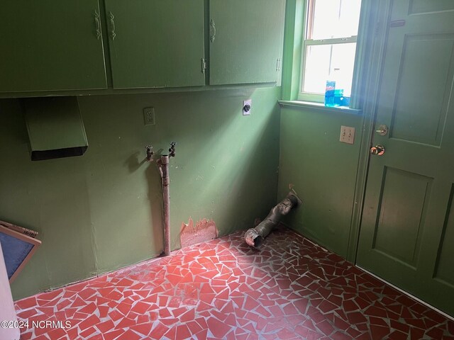 laundry room featuring electric dryer hookup and cabinets