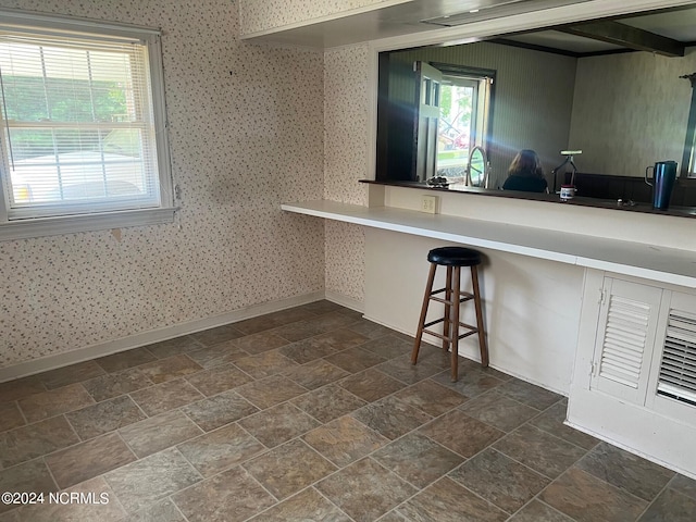 kitchen featuring light countertops, stone finish flooring, and baseboards