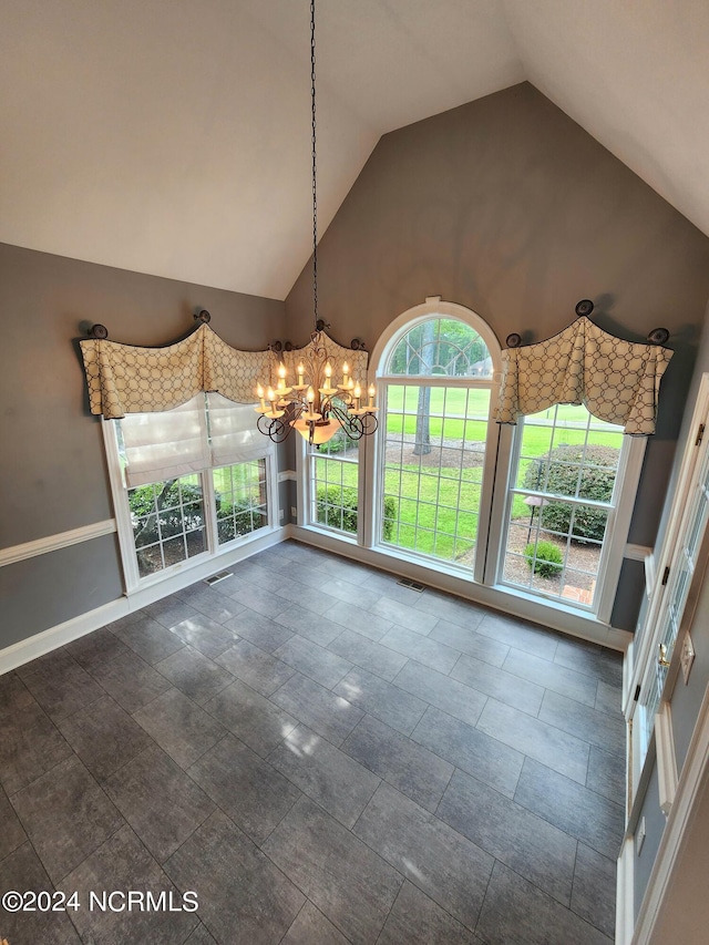 unfurnished dining area with baseboards, visible vents, high vaulted ceiling, and an inviting chandelier