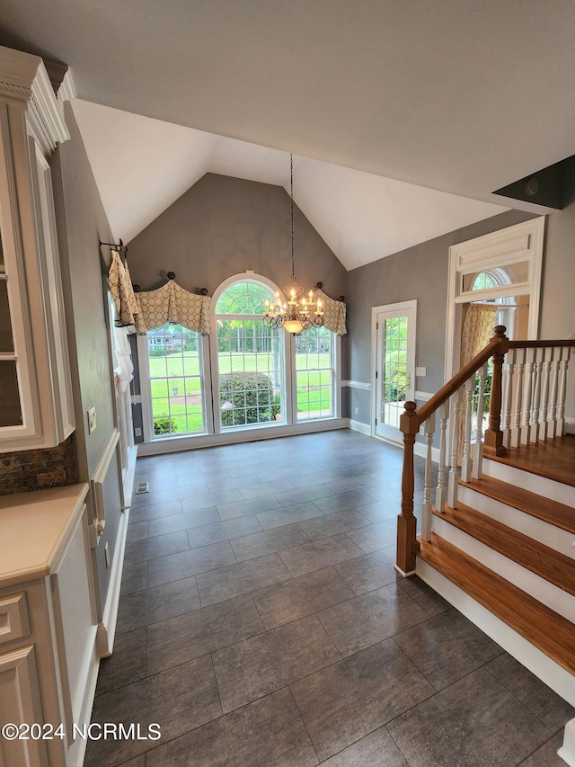 interior space with lofted ceiling, an inviting chandelier, and stairs