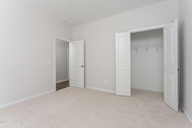 unfurnished bedroom with a closet and light carpet