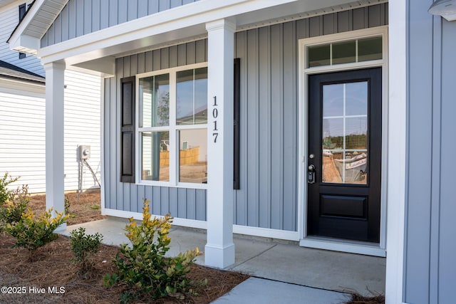 doorway to property with covered porch and board and batten siding