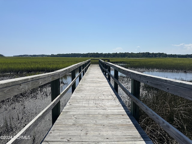 view of dock with a rural view and a water view