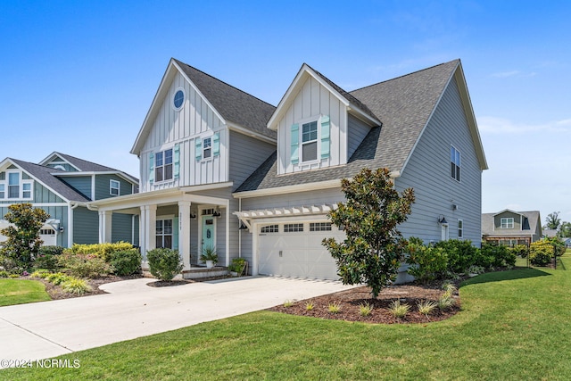 view of front of home with a front yard, covered porch, and a garage