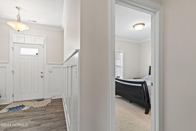 foyer entrance with dark wood-type flooring, crown molding, and plenty of natural light