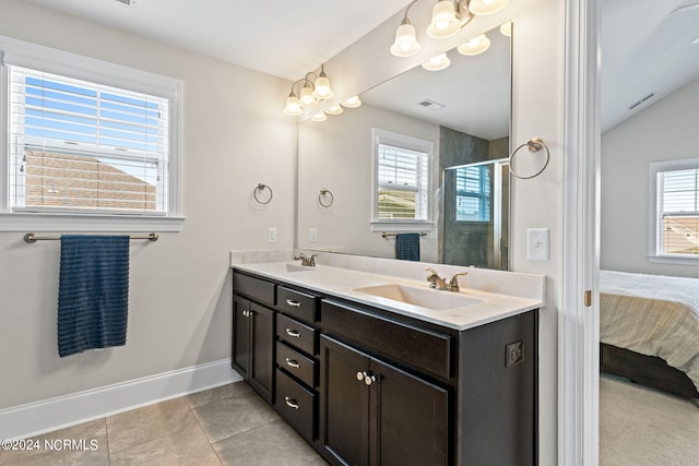 bathroom featuring vanity, tile patterned floors, a shower with shower door, and plenty of natural light