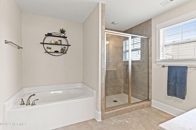 bathroom with tile patterned floors and shower with separate bathtub